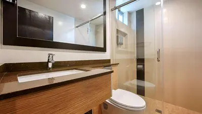 a bathroom with a sink and a toilet and a mirror at Best Western Plus Glendale in Glendale