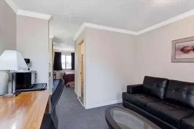 a living room with a couch and a television at Travelodge by Wyndham Pasadena Central in Pasadena
