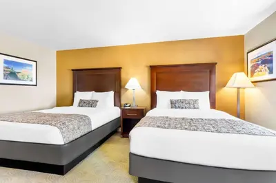 two beds in a hotel room with two lamps at Best Western California City Inn & Suites in California City