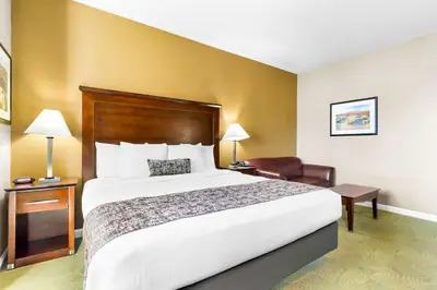 a hotel room with a large bed and a chair at Best Western California City Inn & Suites in California City