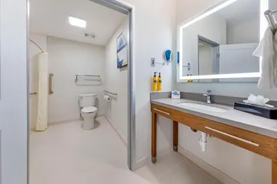 a bathroom with a sink and a toilet and a mirror at Executive Residency by Best Western Victorville in Victorville