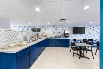 a large kitchen with blue cabinets and a table at Executive Residency by Best Western Victorville in Victorville