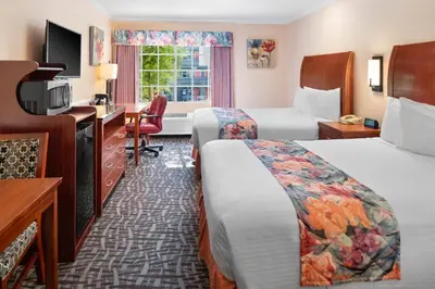 a hotel room with two beds and a desk at Glendale Hotel in Glendale