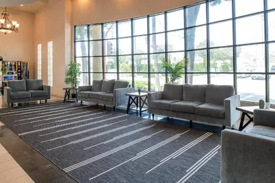 a waiting room with couches and a large window at Glendale Hotel in Glendale