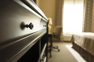 a dresser in a bedroom with a bed and a window at Ayres Hotel Orange in Anaheim