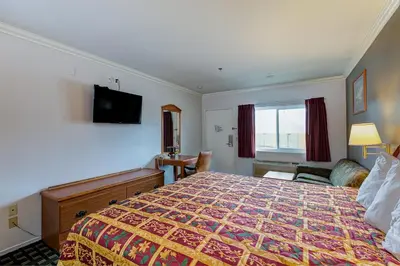 a hotel room with a bed and a flat screen tv at Buena Vista Inn in Anaheim