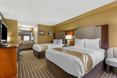 a hotel room with two beds and a flat screen tv at Quality Inn & Suites Westminster Seal Beach in Westminster
