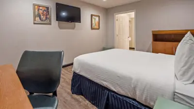a bedroom with a bed and a desk and a chair at Motel 6 Ridgecrest, CA China Lake in Ridgecrest