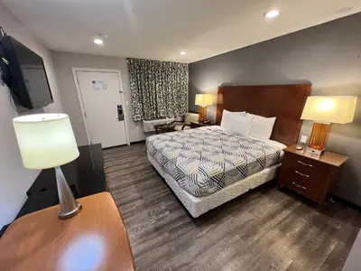 a hotel room with a bed and a table with a lamp at Motel 6 Ridgecrest, CA China Lake in Ridgecrest