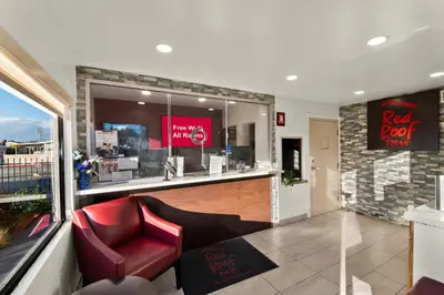 a restaurant with a red chair and a bar at Red Roof Inn Los Angeles - Bellflower in Bellflower