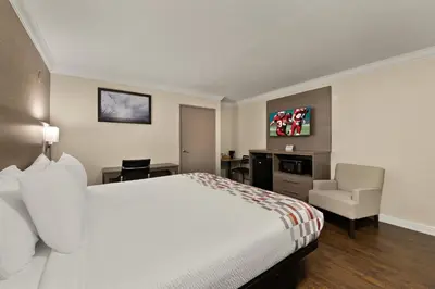 a hotel room with a bed and a chair at Red Roof Inn Los Angeles - Bellflower in Bellflower