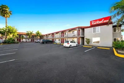 a hotel with cars parked in a parking lot at Red Roof Inn Los Angeles - Bellflower in Bellflower