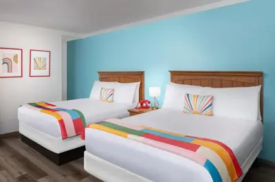 two beds in a room with blue walls at The Sojourn Los Angeles - Sherman Oaks in Sherman Oaks