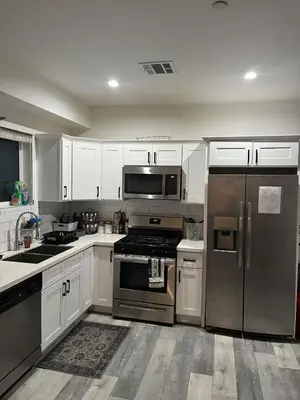 a kitchen with stainless steel appliances and white cabinets at Modern Hostel address changed in Los Angeles
