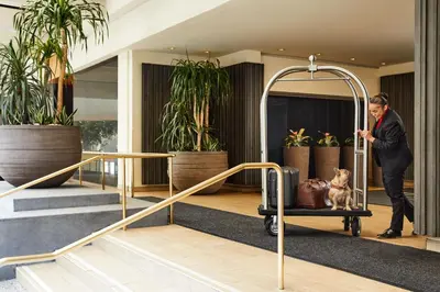 a man with a dog in a cart in a lobby at The Westin Bonaventure Hotel & Suites, Los Angeles in Los Angeles