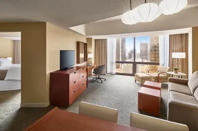 a hotel room with a bed and a desk with a television at The Westin Bonaventure Hotel & Suites, Los Angeles in Los Angeles
