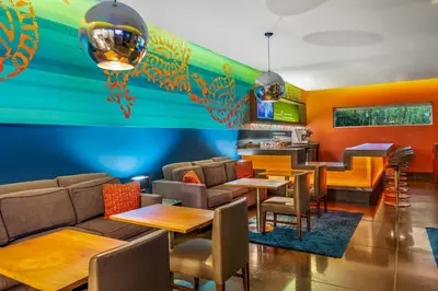 a restaurant with tables and chairs and a bar at SIRTAJ – Beverly Hills in Los Angeles