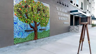 a camera on a tripod next to a painting of a tree at Hampton Inn Riverside Downtown in Riverside