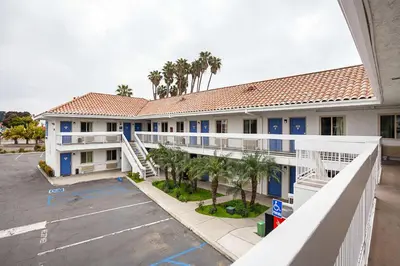 an apartment building with a parking lot and palm trees at Motel 6-Ventura, CA - Downtown in Ventura