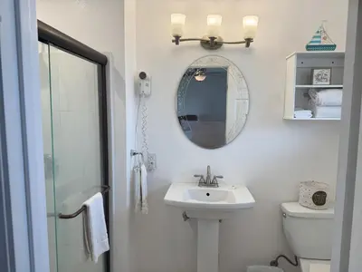 a bathroom with a sink and a mirror and a toilet at Lakeshore Lodge in Wofford Heights