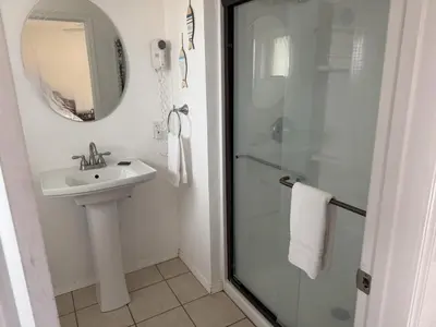 a bathroom with a shower and a sink and a mirror at Lakeshore Lodge in Wofford Heights