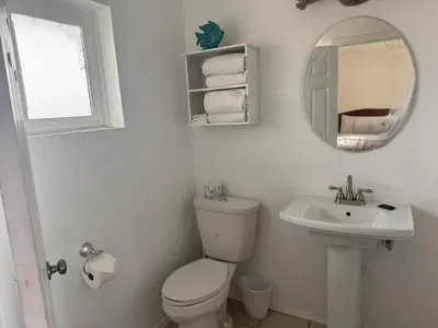 a bathroom with a toilet and a sink and a mirror at Lakeshore Lodge in Wofford Heights