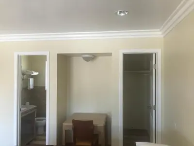 a white room with a table and a bathroom at All 8 Motel in Long Beach
