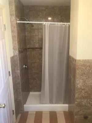 a shower with a shower curtain in a bathroom at All 8 Motel in Long Beach