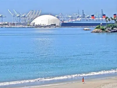 a person walking on the beach next to the ocean at Mid-Mod Retro Private Studio & Pool in Long Beach