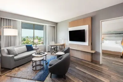 a hotel room with a couch and a bed at Courtyard by Marriott Los Angeles Monterey Park in Monterey Park