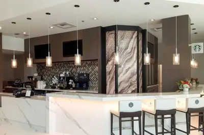 a kitchen with a bar with stools in it at Courtyard by Marriott Los Angeles Monterey Park in Monterey Park