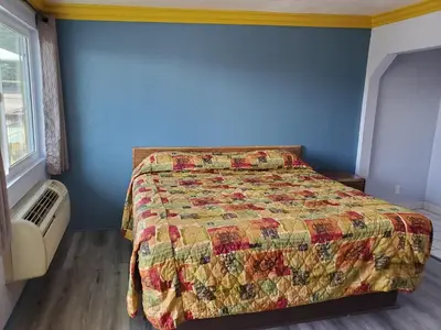 a bedroom with a bed and a blue wall at Rose motel in Compton
