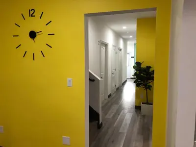 a clock on a yellow wall in a hallway at 8th and Ardmore in Los Angeles
