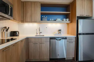 a kitchen with wooden cabinets and a stainless steel refrigerator at Element Ontario Rancho Cucamonga in Ontario