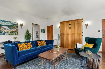 a living room with a blue couch and two chairs at Visit the Beach from a Historic Downtown Apartment - NRP21-00092 in Long Beach
