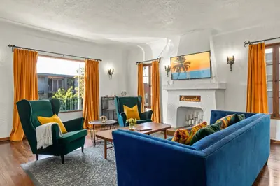 a living room with a blue couch and chairs at Visit the Beach from a Historic Downtown Apartment - NRP21-00092 in Long Beach
