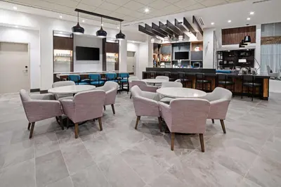 a restaurant with tables and chairs and a bar at Hyatt Place Bakersfield in Bakersfield