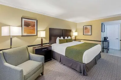 a hotel room with a bed and a chair at Best Western Canoga Park Motor Inn in Canoga Park