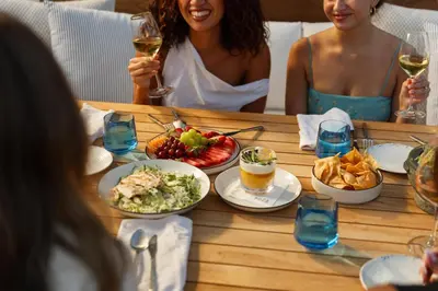a group of people sitting around a table with food at L'Ermitage Beverly Hills in Los Angeles
