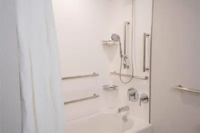 a white bathroom with a shower and a sink at Courtyard by Marriott Thousand Oaks Agoura Hills in Agoura Hills