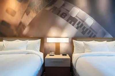 a hotel room with two beds and a nightstand between them at Courtyard by Marriott Thousand Oaks Agoura Hills in Agoura Hills