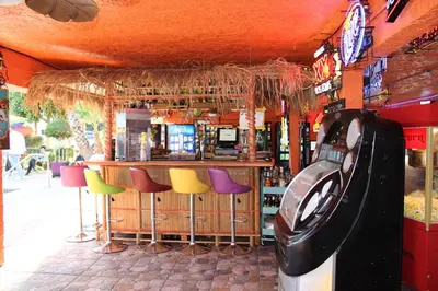 a bar with colorful bar stools and a pool at Tradewinds Airport Hotel in Inglewood