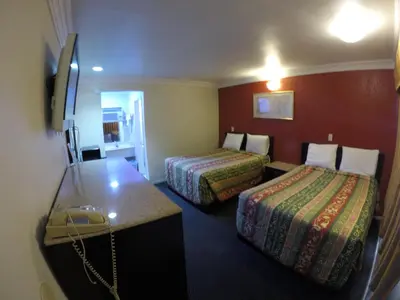 a hotel room with two beds and a desk at Calico Motel in Anaheim