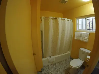 a bathroom with a white toilet and a shower at Calico Motel in Anaheim