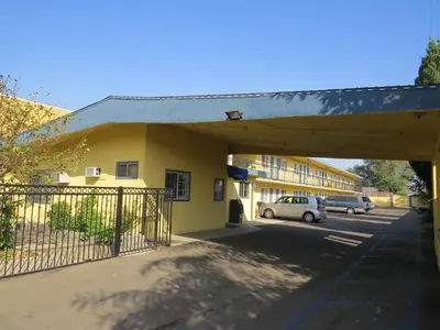 a building with cars parked in a parking lot at Calico Motel in Anaheim