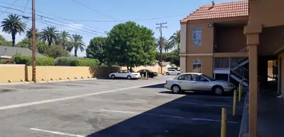 two cars parked in a parking lot next to a building at Lotus by Hotel Inn in Ontario