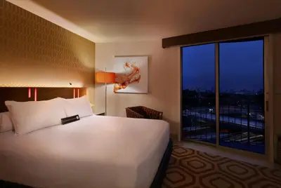 a bedroom with a large white bed and a large window at Hotel Angeleno in Los Angeles