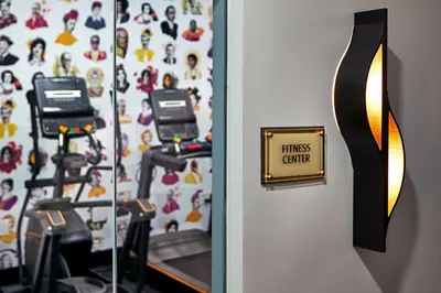 a fitness center with three exercise bikes on a wall at Elan Hotel in Los Angeles