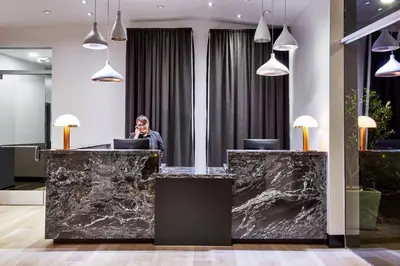 a woman is sitting at a desk in a lobby at Elan Hotel in Los Angeles