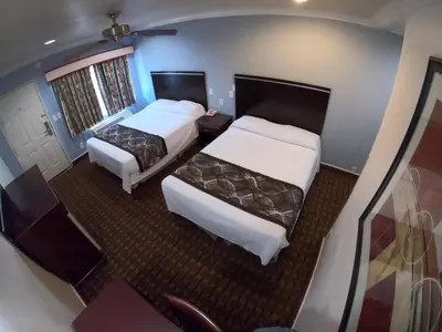 a hotel room with two beds and a balcony at Hollywood Guest Inn in Los Angeles